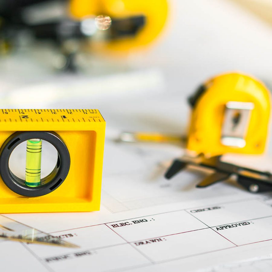 Construction plans with helmet and drawing tools on blueprints